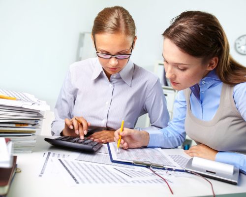 Concentrated business women reviewing accounting report
