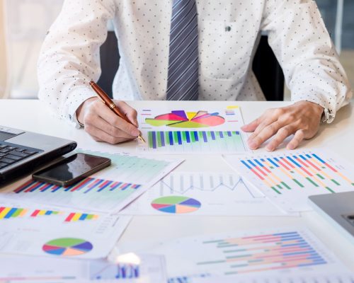 Working process startup. Businessman working at the wood table with new finance project. Modern notebook on table. Pen holding hand